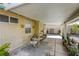 Covered patio with seating area, surrounded by potted plants, ideal for outdoor dining and relaxation at 40 Trailside Ct, Henderson, NV 89012