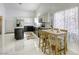 Dining area with marble floors and natural light, connected to the kitchen with island and stainless appliances at 40 Trailside Ct, Henderson, NV 89012