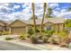 Charming single-story home with a tile roof and desert landscaping, including palm trees, cacti and gravel beds at 40 Trailside Ct, Henderson, NV 89012