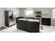 Modern kitchen featuring black and white cabinetry, stainless steel appliances, and a center island at 40 Trailside Ct, Henderson, NV 89012