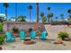 Relaxing backyard seating area with a fire pit, surrounded by lush greenery and palm trees at 4617 Gonzales Dr, Las Vegas, NV 89130