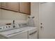 A laundry room with cabinets, a hanging ironing board and modern washer and dryer at 4617 Gonzales Dr, Las Vegas, NV 89130