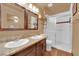Bathroom featuring double sinks, wood-look floors, and glass-enclosed shower at 5222 Joshua Jose St, North Las Vegas, NV 89031