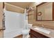 Well-lit bathroom showcases a tiled shower-tub, a toilet, a granite countertop and a large vanity mirror at 5222 Joshua Jose St, North Las Vegas, NV 89031