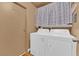 Convenient laundry room includes a washer, dryer, shelving, and a door to another room at 5222 Joshua Jose St, North Las Vegas, NV 89031