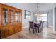 An elegant dining room featuring a large wood cabinet, dining table with 8 chairs, and stylish light fixture at 5301 Kalmia Dr, Las Vegas, NV 89103