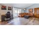 Comfortable living room featuring a large window, wood flooring, and a leather sectional couch at 5301 Kalmia Dr, Las Vegas, NV 89103