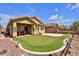 Charming backyard featuring a well-manicured lawn, a putting green and a cozy patio area at 5681 Harbour Pointe Ave, Las Vegas, NV 89122