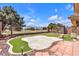 Spacious backyard with a synthetic putting green, desert landscaping, and a fenced perimeter at 5681 Harbour Pointe Ave, Las Vegas, NV 89122