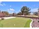 Backyard features artificial turf, putting green, and a wrought iron fence overlooking a lake at 5681 Harbour Pointe Ave, Las Vegas, NV 89122