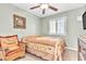 Cozy bedroom with ceiling fan, shuttered window, framed art, and a comfortable wicker chair at 5681 Harbour Pointe Ave, Las Vegas, NV 89122