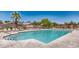Relaxing community pool with several lounge chairs, a large palm tree, and mountain views at 5681 Harbour Pointe Ave, Las Vegas, NV 89122