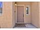 Inviting front entry showcasing a tan door, a welcome mat, and charming exterior architecture at 5681 Harbour Pointe Ave, Las Vegas, NV 89122