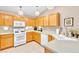 Well-lit kitchen with wood cabinets, white appliances, and bright countertops at 5681 Harbour Pointe Ave, Las Vegas, NV 89122