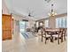 Open-concept living and dining area with tile floors, ceiling fan, and natural light from a sliding glass door at 5681 Harbour Pointe Ave, Las Vegas, NV 89122