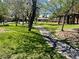 Scenic neighborhood park with mature trees, green grass, and a paved walking path at 5681 Harbour Pointe Ave, Las Vegas, NV 89122