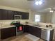 The well-lit kitchen features dark cabinets, stainless steel appliances, and hardwood floors at 5904 Oakton St, Las Vegas, NV 89130