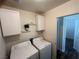 Convenient laundry room includes washer, dryer, overhead cabinets, and decorative shelving at 5904 Oakton St, Las Vegas, NV 89130