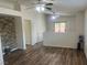 Bright living room features wood-look flooring, a stone accent wall, and sliding glass doors to the outdoor space at 5904 Oakton St, Las Vegas, NV 89130
