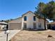 Two-story home with a two-car garage, neutral tones, and a xeriscaped front yard under a clear, blue sky at 5928 Willard St, Las Vegas, NV 89122