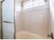 Bathtub and shower combo with clear glass doors and tiled surround in a bathroom at 6149 Elderberry Wine Ave, Las Vegas, NV 89142