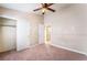 Bedroom with carpeted floors, a ceiling fan, closet, and an adjoining bathroom at 6149 Elderberry Wine Ave, Las Vegas, NV 89142