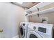Bright laundry room with white Samsung washer and dryer, plus convenient overhead storage shelves at 6149 Elderberry Wine Ave, Las Vegas, NV 89142
