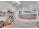 Pink themed bedroom with a bunk bed, storage drawers, shelves and a ceiling fan at 6314 Shadow Moon Pl, North Las Vegas, NV 89031