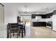 Open kitchen and dining area with modern black cabinetry, stainless steel appliances, and access to backyard at 6314 Shadow Moon Pl, North Las Vegas, NV 89031