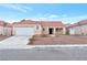 Charming single-story home with a red tile roof and a two-car garage in a suburban neighborhood at 635 Dry Valley Ave, North Las Vegas, NV 89031