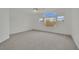 Bright bedroom featuring neutral carpeting, three windows, and views of the surrounding neighborhood at 6927 Adobe Villa Ave, Las Vegas, NV 89142