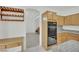 Kitchen featuring built-in oven, wooden cabinets, stone countertops and wine rack at 6927 Adobe Villa Ave, Las Vegas, NV 89142