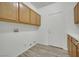 Bright laundry area boasts wood cabinets, white walls and trim, and convenient washer and dryer hookups at 6927 Adobe Villa Ave, Las Vegas, NV 89142
