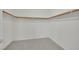 Well-organized walk-in closet offers neutral carpeting and wood shelves and clothing racks at 6927 Adobe Villa Ave, Las Vegas, NV 89142