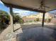 Covered patio with ceiling fan overlooking the gravel backyard with garden beds at 7062 Russell Ranch Ave, Las Vegas, NV 89113