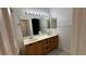 Bathroom featuring double sinks, wood cabinets, and large mirror, a comfortable design at 7062 Russell Ranch Ave, Las Vegas, NV 89113