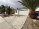 Street view showcasing a single-story home, concrete driveway, desert landscaping, and mature palm trees at 7062 Russell Ranch Ave, Las Vegas, NV 89113