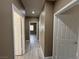 Well-lit hallway with white doors and grey wood flooring, freshly painted at 7062 Russell Ranch Ave, Las Vegas, NV 89113