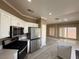 White kitchen with stainless steel appliances, quartz counters, and hardwood flooring at 7062 Russell Ranch Ave, Las Vegas, NV 89113