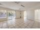 Open living room with tile flooring, sliding glass doors and views to a side entrance and outdoor space at 7176 Fenway Ave, Las Vegas, NV 89147