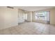 Open living room featuring tile floors, staircase, large front window and front door at 7176 Fenway Ave, Las Vegas, NV 89147