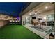 Outdoor entertaining space with covered patio, dining area, and lush artificial lawn at 746 Horizon Canyon Dr, Henderson, NV 89052