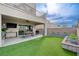 Back patio features an outdoor dining table, TV, and lush artificial turf lawn at 746 Horizon Canyon Dr, Henderson, NV 89052