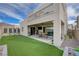 A backyard with a covered patio, dining area, and manicured artificial turf provides a perfect outdoor entertaining and relaxation space at 746 Horizon Canyon Dr, Henderson, NV 89052