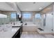 A modern bathroom boasts a soaking tub, glass-enclosed shower, dual sinks, and neutral tones for a serene and spa-like retreat at 746 Horizon Canyon Dr, Henderson, NV 89052