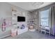 A charming bedroom includes a desk, shelves for books and toys, and a window for a cozy, playful, and functional space at 746 Horizon Canyon Dr, Henderson, NV 89052
