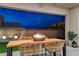 Charming covered patio featuring stylish wicker chairs, a fire pit, and serene outdoor lighting at 746 Horizon Canyon Dr, Henderson, NV 89052