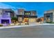 Modern two-story home featuring a glass panel garage door, desert landscaping, and exterior lighting at 746 Horizon Canyon Dr, Henderson, NV 89052