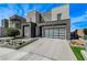 Stylish modern home exterior featuring a gray color palette, glass garage door, and desert landscaping at 746 Horizon Canyon Dr, Henderson, NV 89052