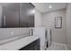 A well-organized laundry room features ample cabinet space, a utility sink, and modern washer and dryer units at 746 Horizon Canyon Dr, Henderson, NV 89052